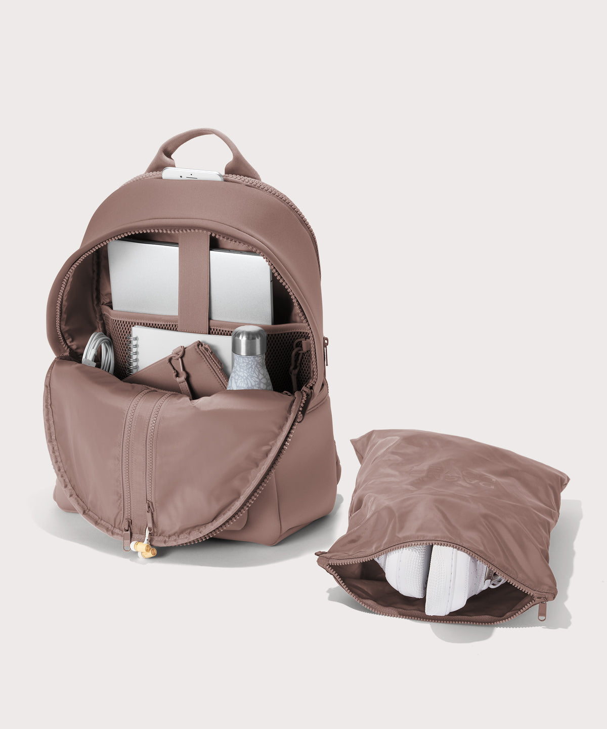 Dagne Dover large Dakota Neoprene Backpack in pink unzipped, showing the interior pockets and shoe bag.
