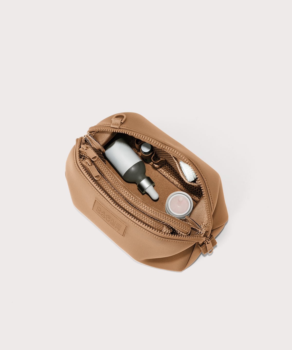 Dagne Dover Large Hunter Toiletry Bag in camel brown unzipped and seen from above.
