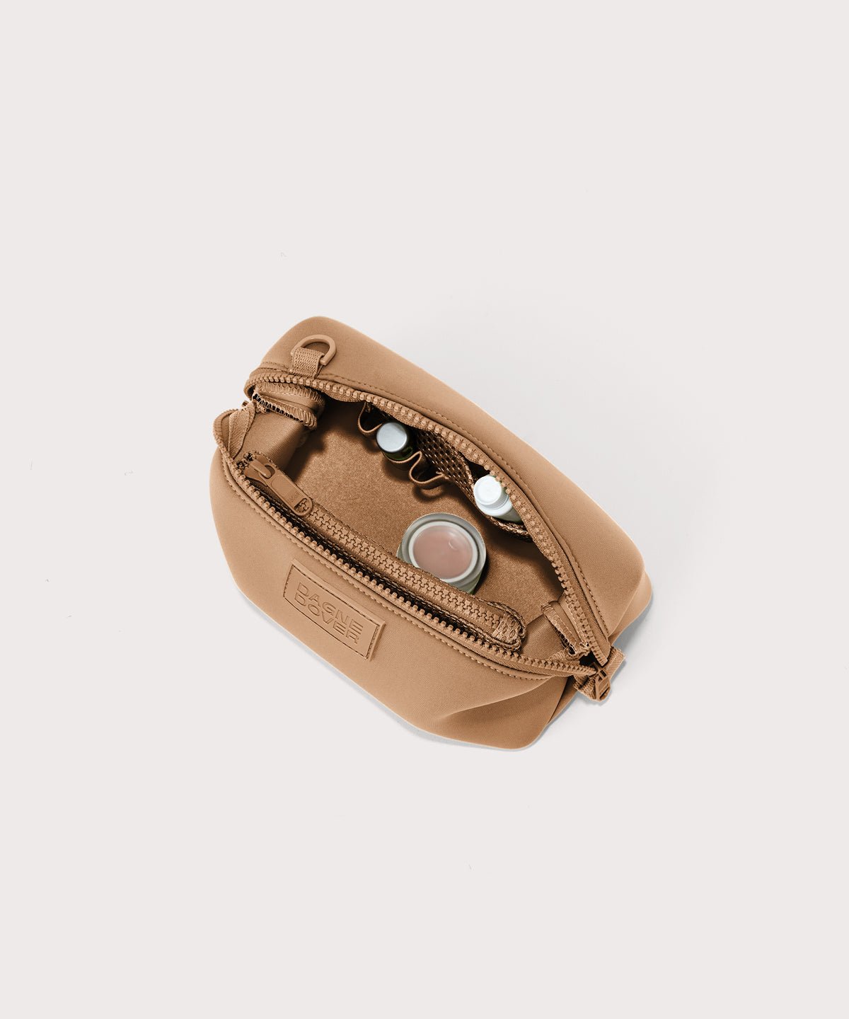 Dagne Dover Small Hunter Toiletry Bag in camel unzipped and seen from above.
