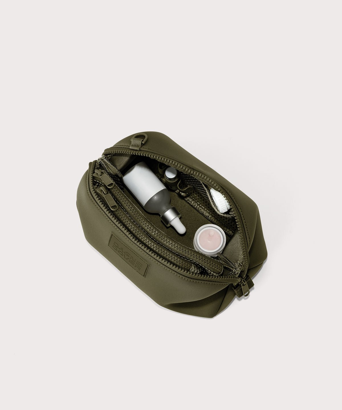 Dagne Dover Large Hunter Toiletry Bag in dark moss unzipped and seen from above.
