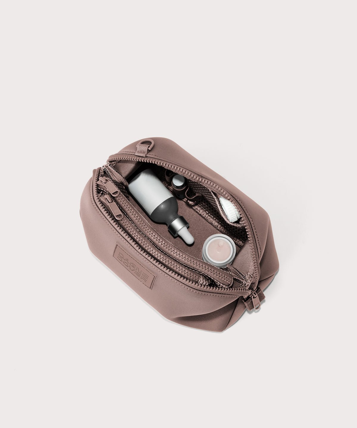 Dagne Dover Large Hunter Toiletry Bag in pink unzipped and seen from above.
