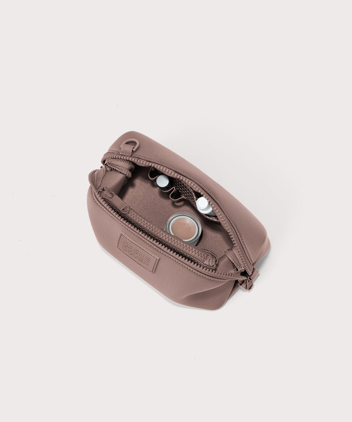 Dagne Dover Small Hunter Toiletry Bag in pink unzipped and seen from above.
