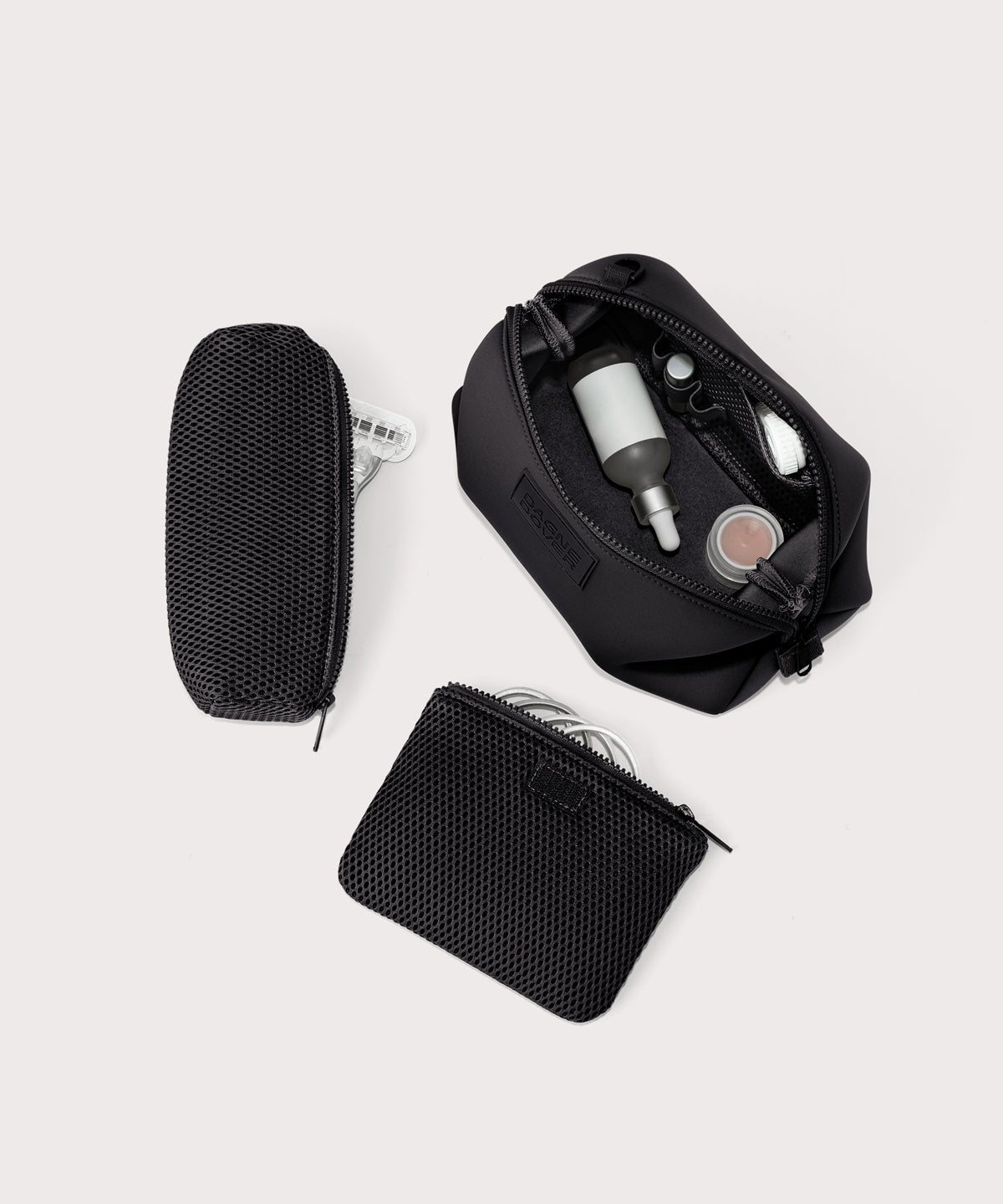 Dagne Dover Large Hunter Toiletry Bag in black unzipped and seen from above with the removable air mesh pouch alongside it.
