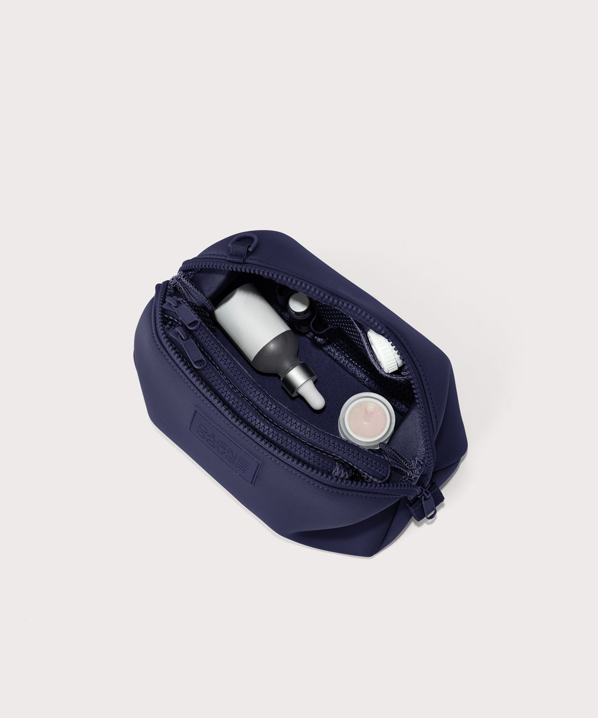 Dagne Dover Large Hunter Toiletry Bag in dark blue unzipped and seen from above.
