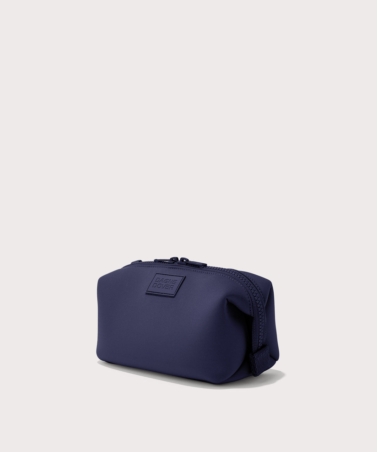 Dagne Dover Small Hunter Toiletry Bag in dark blue seen from an angle.
