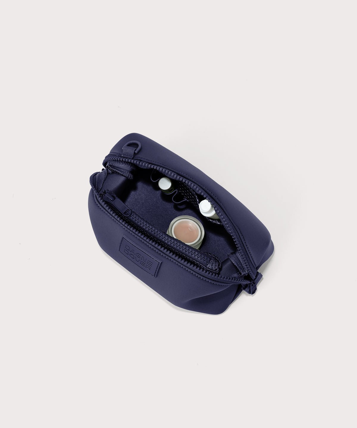 Dagne Dover Small Hunter Toiletry Bag in dark blue unzipped and seen from above.
