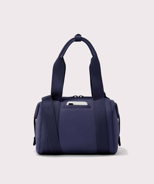 small Landon Carryall in dark blue, displaying an exterior phone pocket
