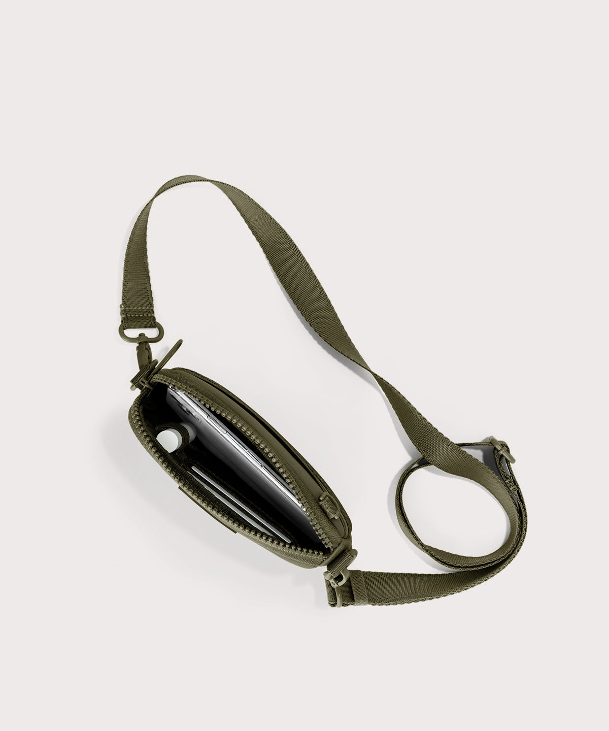 Dagne Dover Mara Phone Sling unzipped in dark green seen from above, exposing the interior card slots.