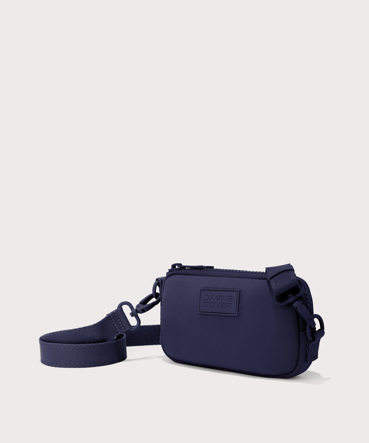Dagne Dover Mara Phone Sling in dark blue seen from an angle, showing the adjustable shoulder strap drop.
