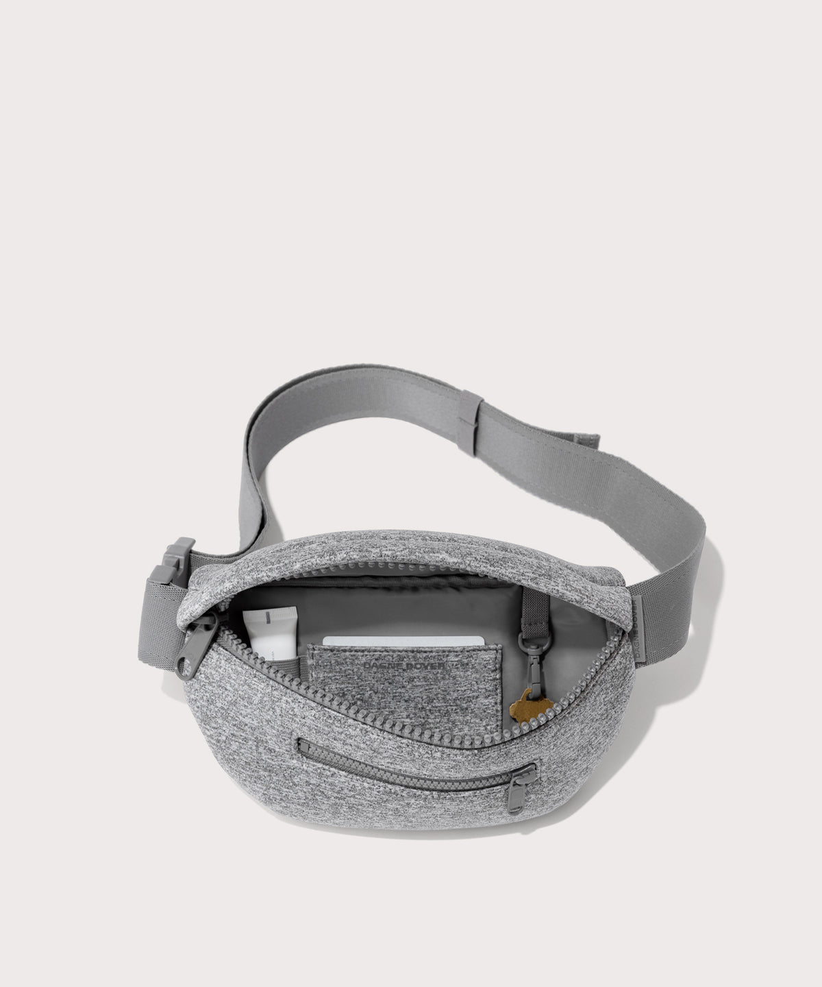 Dagne Dover Ace Fanny Pack in grey  unzipped, exposing the interior pockets
