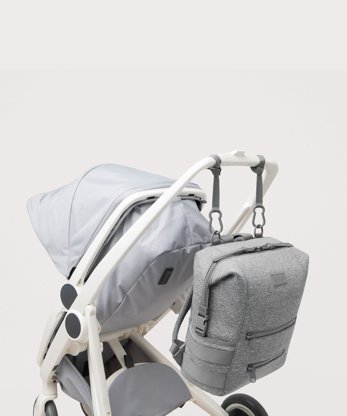 Dagne Dover Large Indi Diaper Backpack in grey attached to a stroller.
