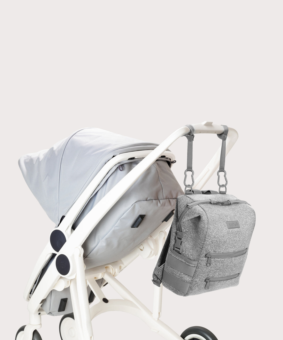 Dagne Dover medium Indi Diaper Backpack in grey attached to a stroller.

