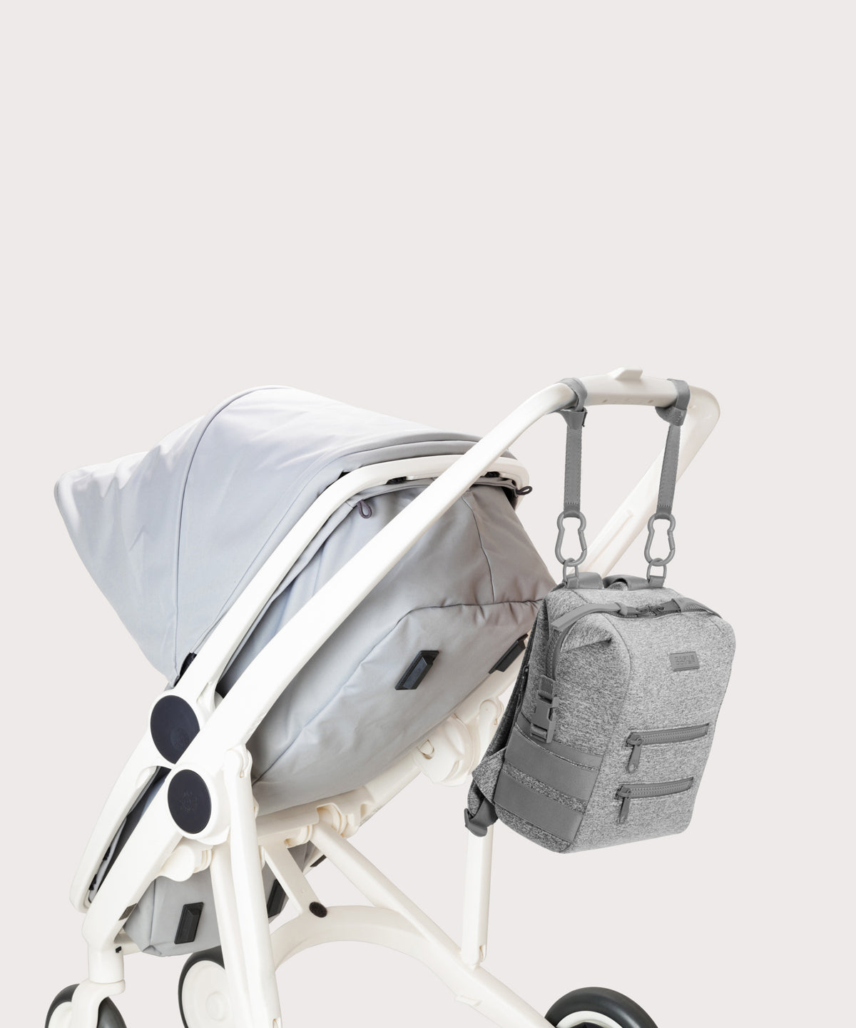 Dagne Dover small Indi Diaper Backpack in grey attached to a stroller.
