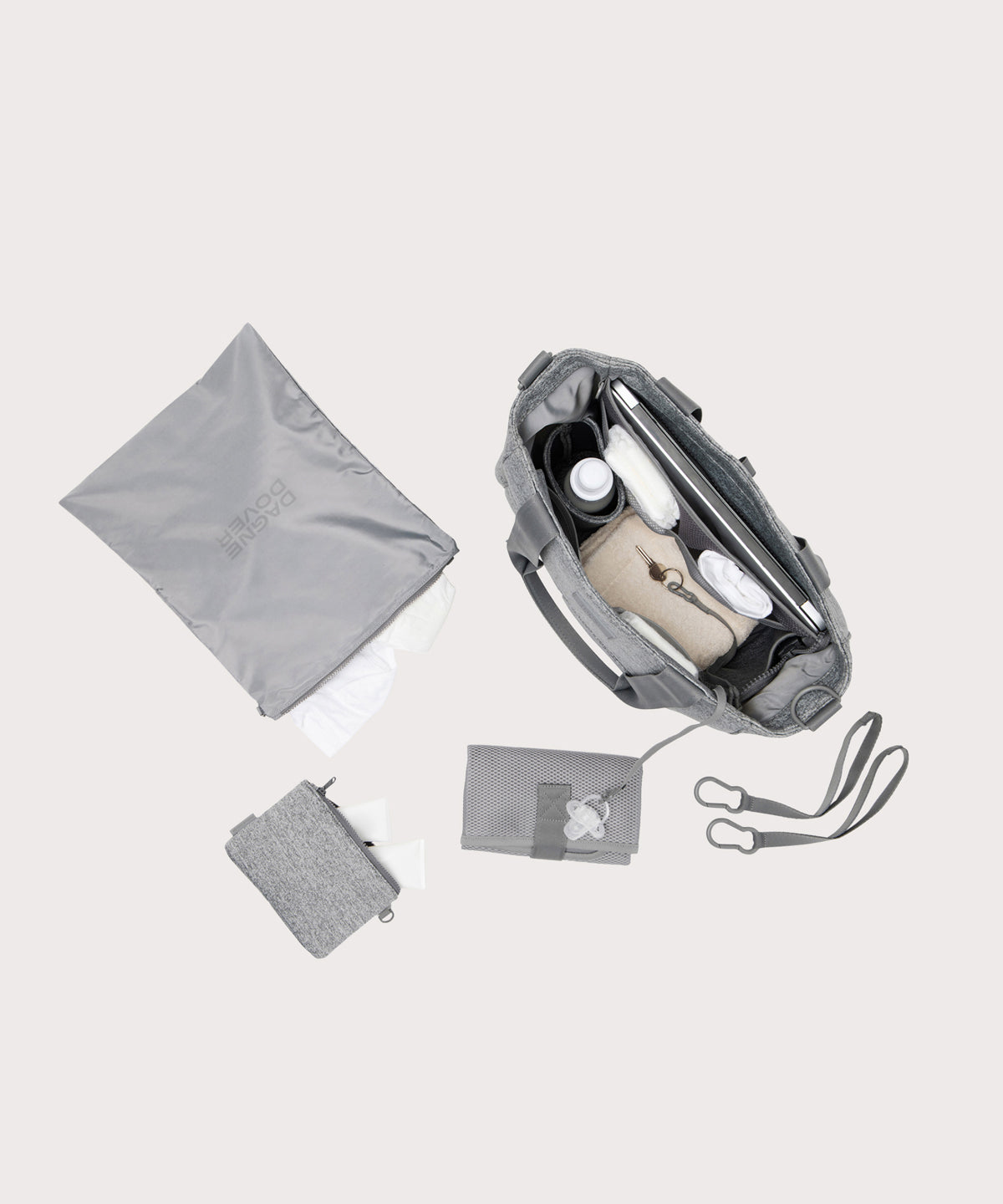 Dagne Dover large Wade Diaper Tote in grey seen from above, alongside the changing mat, neoprene pouch, and water resistant zipper bag.