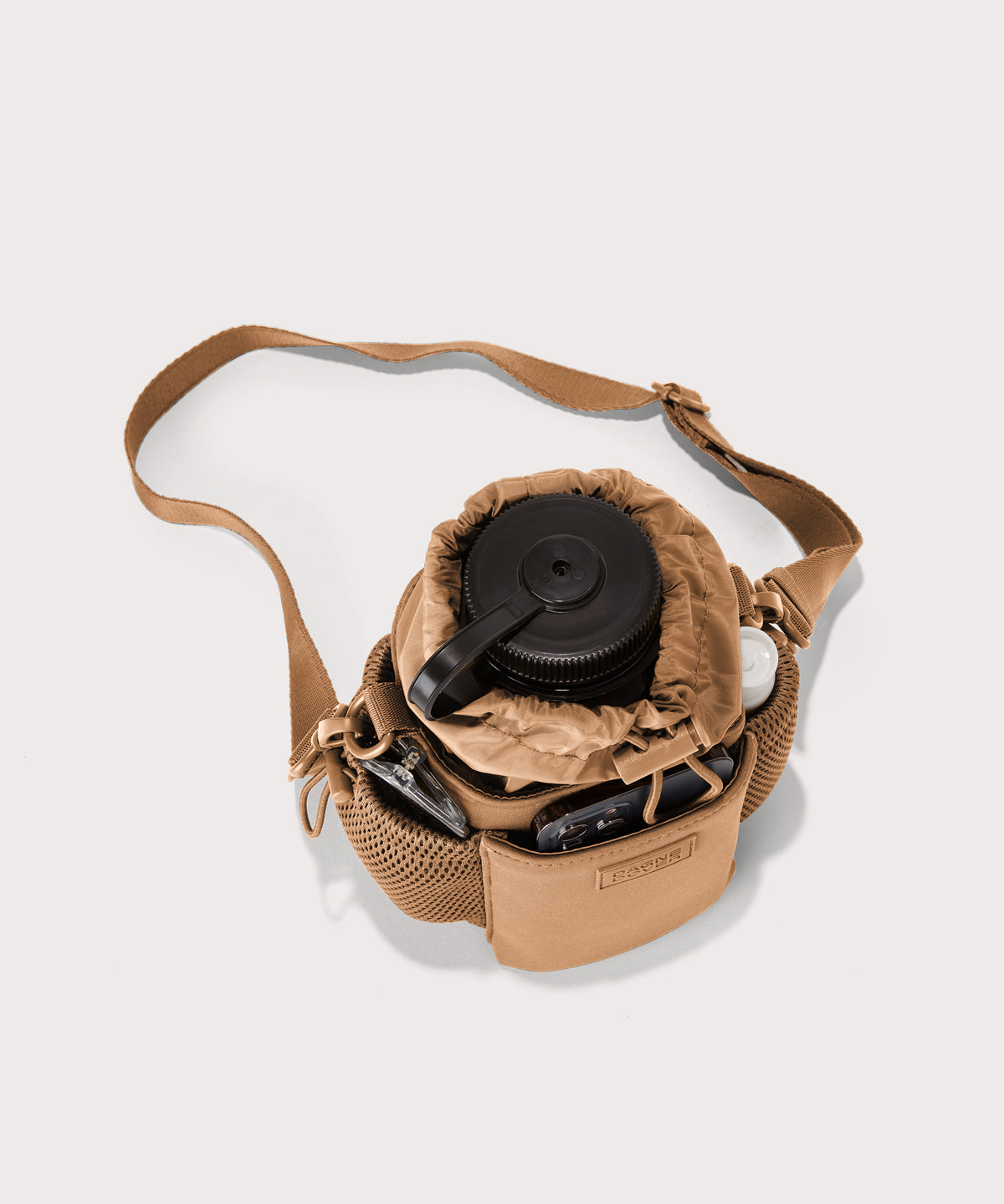 Dagne Dover Sloan Water Bottle Sling in camel brown seen from above containing a water bottle and accessories 