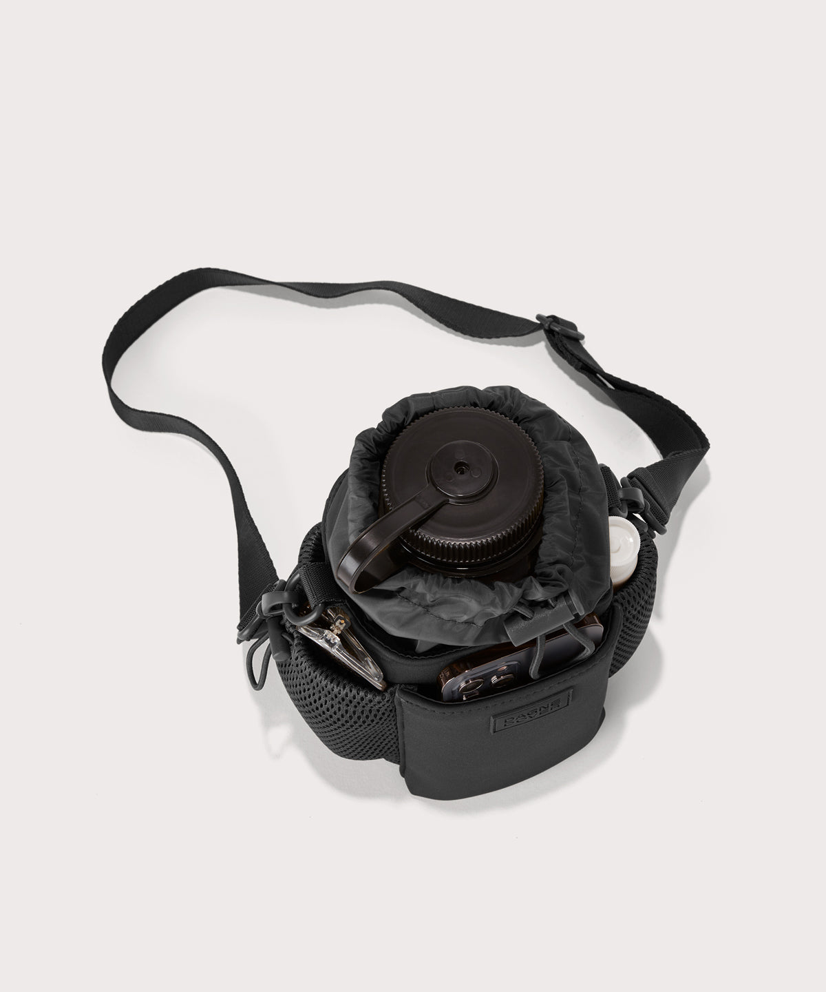 Dagne Dover Sloan Water Bottle Sling in black seen from above containing a water bottle and accessories 