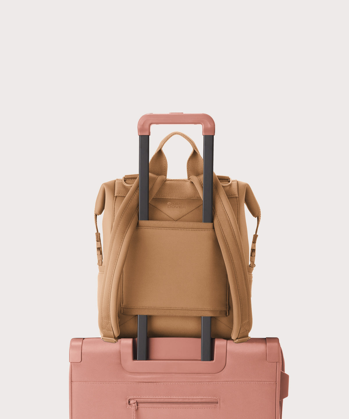 Dagne Dover Medium Indi Diaper Backpack in camel brown showing the neoprene luggage sleeve.
