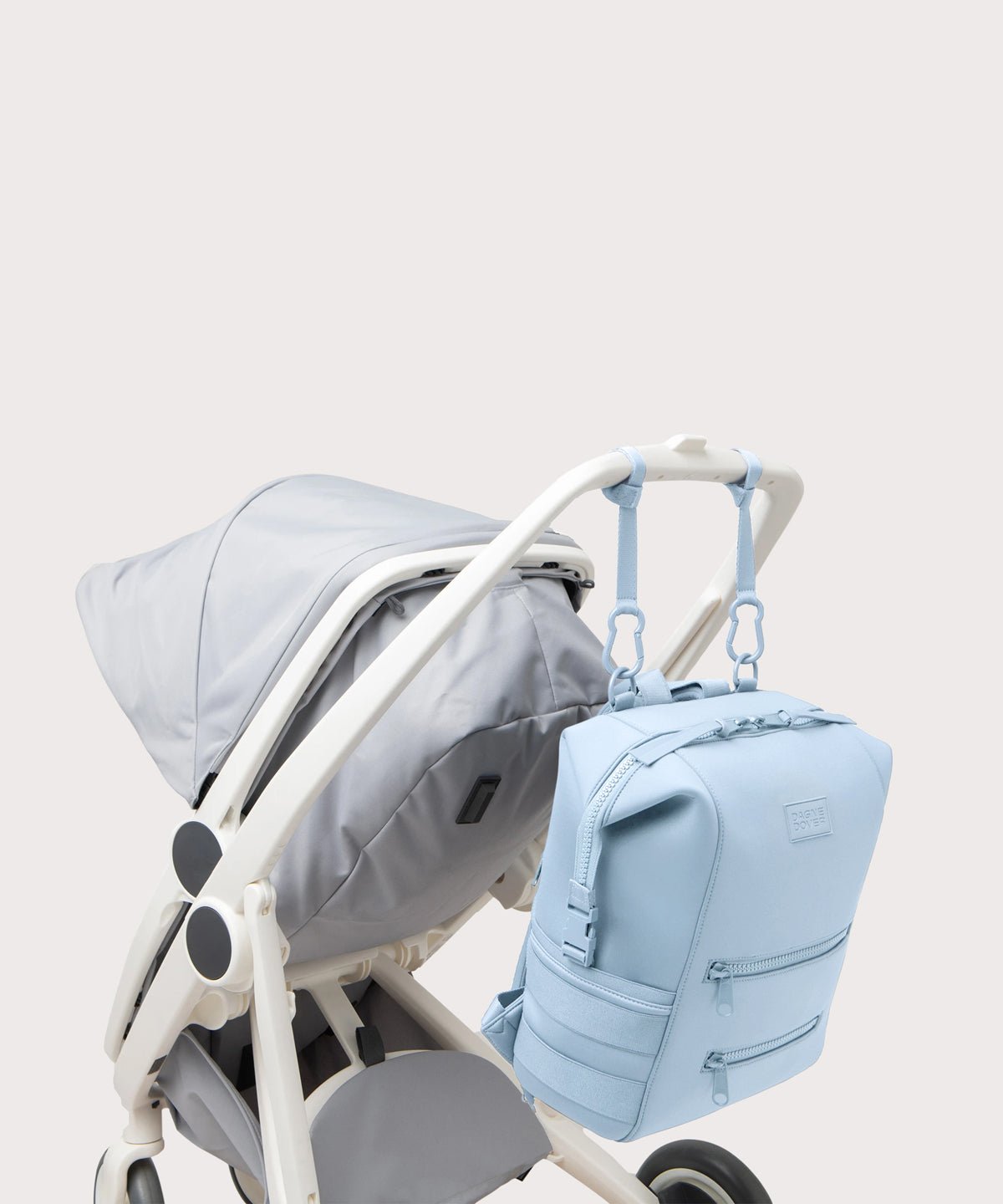 Dagne Dover Large Indi Diaper Backpack in an airy, lighter sky blue attached to a stroller.
