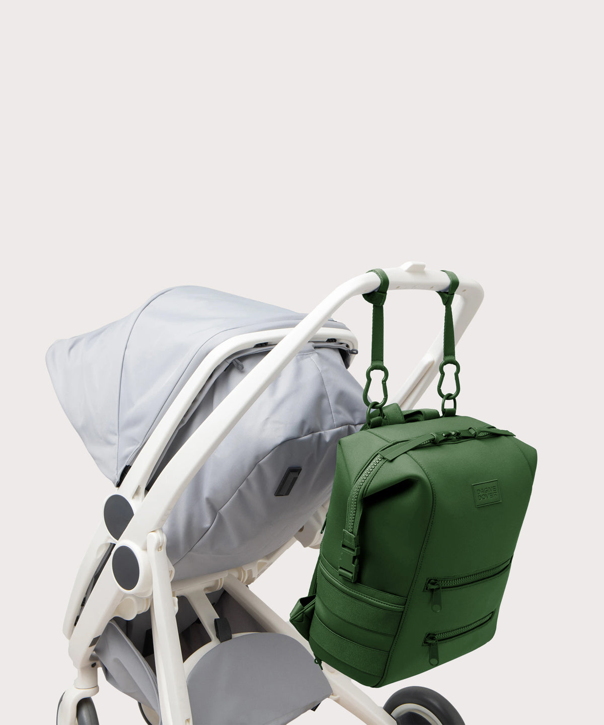Dagne Dover Large Indi Diaper Backpack in a rich, classic forest green attached to a stroller.
