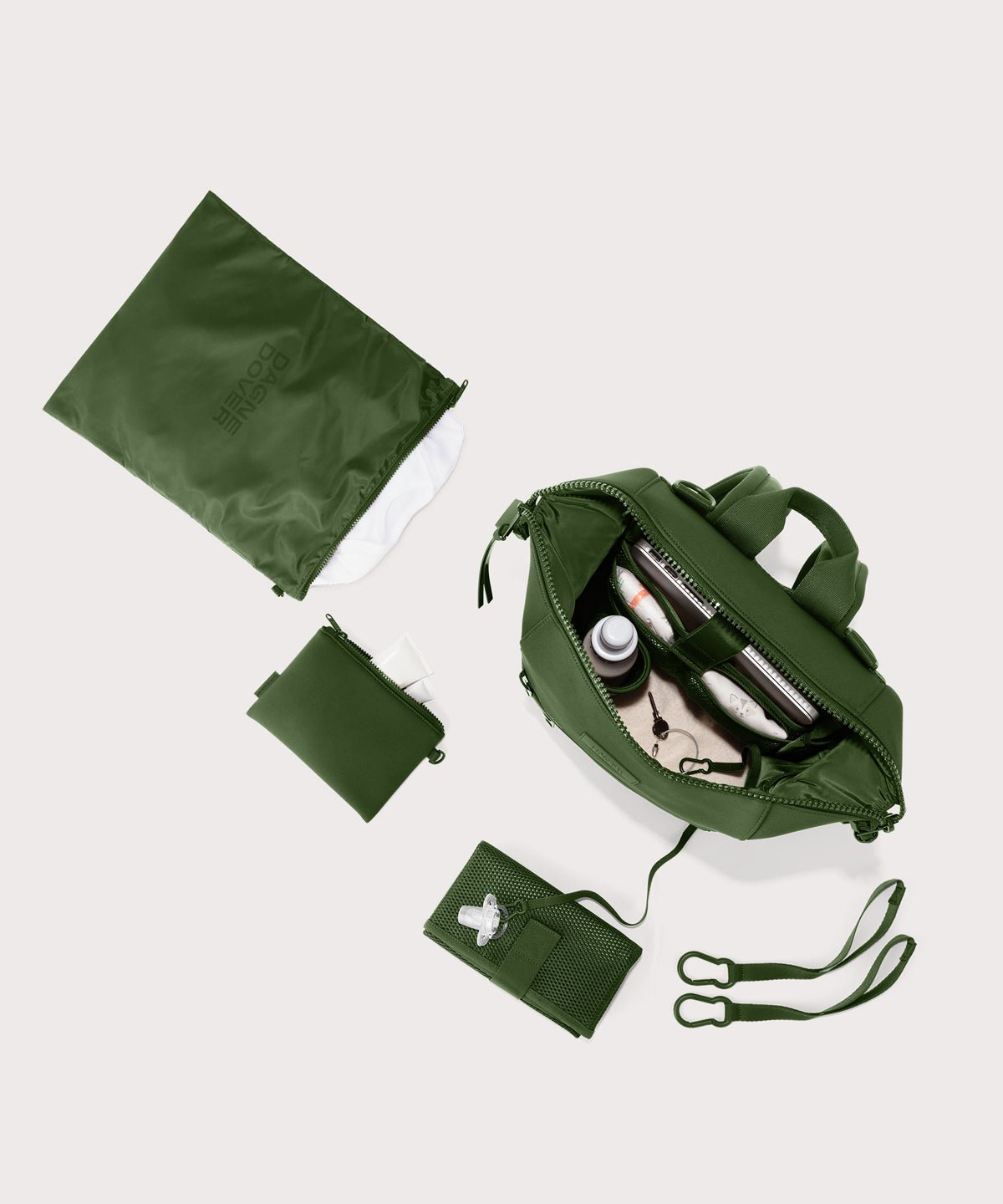 Dagne Dover Medium Indi Diaper Backpack in a rich, classic forest green. showing it's water resistant bag, interior pockets, and changing mat.