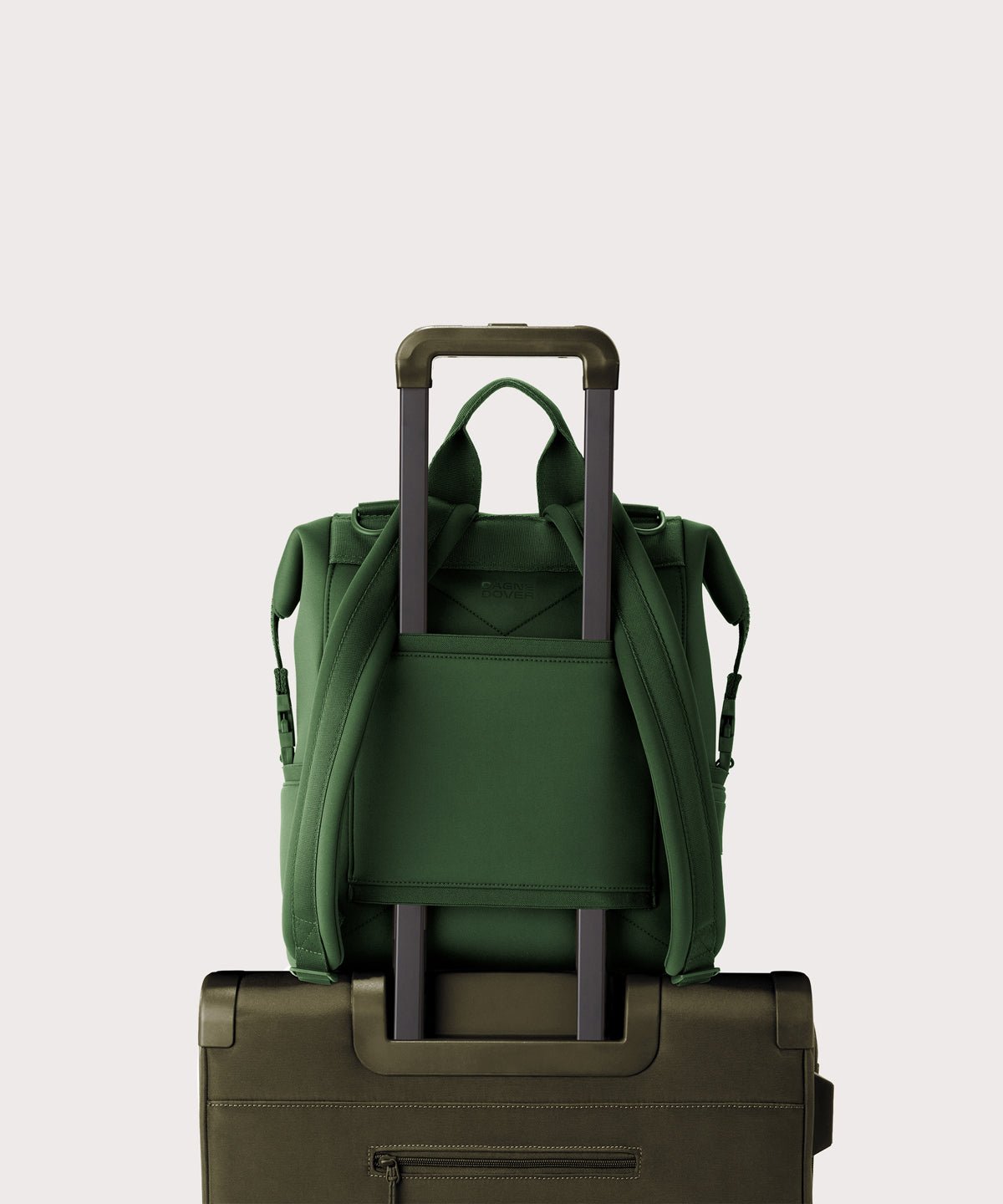 Dagne Dover Medium Indi Diaper Backpack in a rich, classic forest green. showing the neoprene luggage sleeve.
