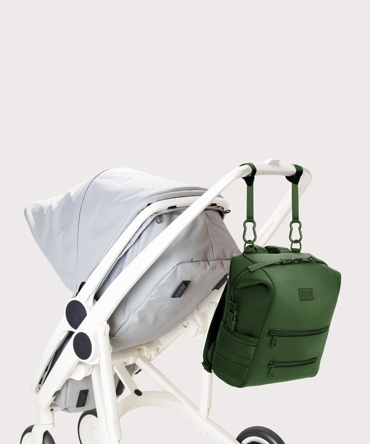 Dagne Dover Medium Indi Diaper Backpack in a rich, classic forest green. attached to a stroller.
