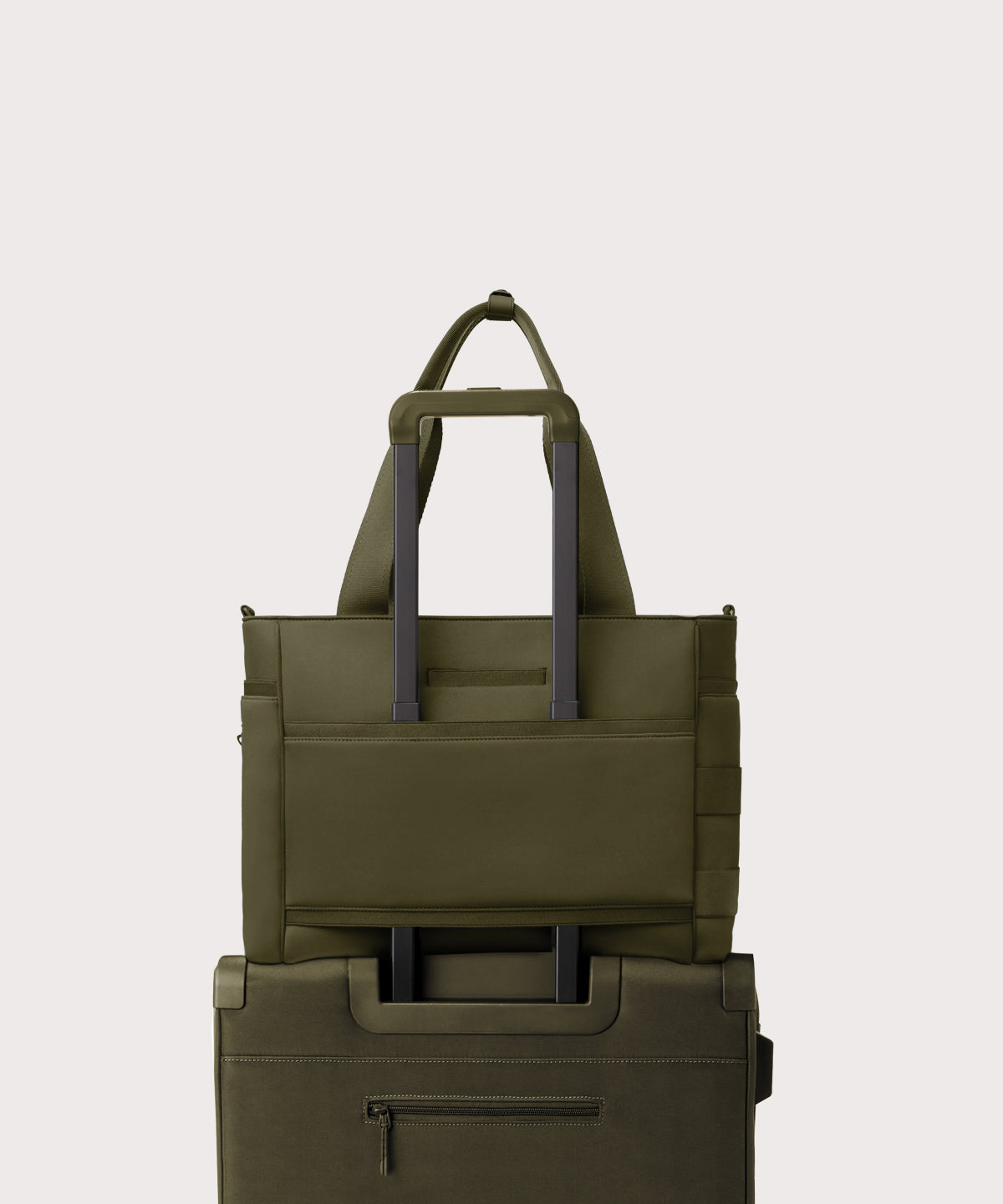 Dagne Dover large Wade Diaper Tote in dark green with the neoprene luggage sleeve attached to a suitcase handle.
