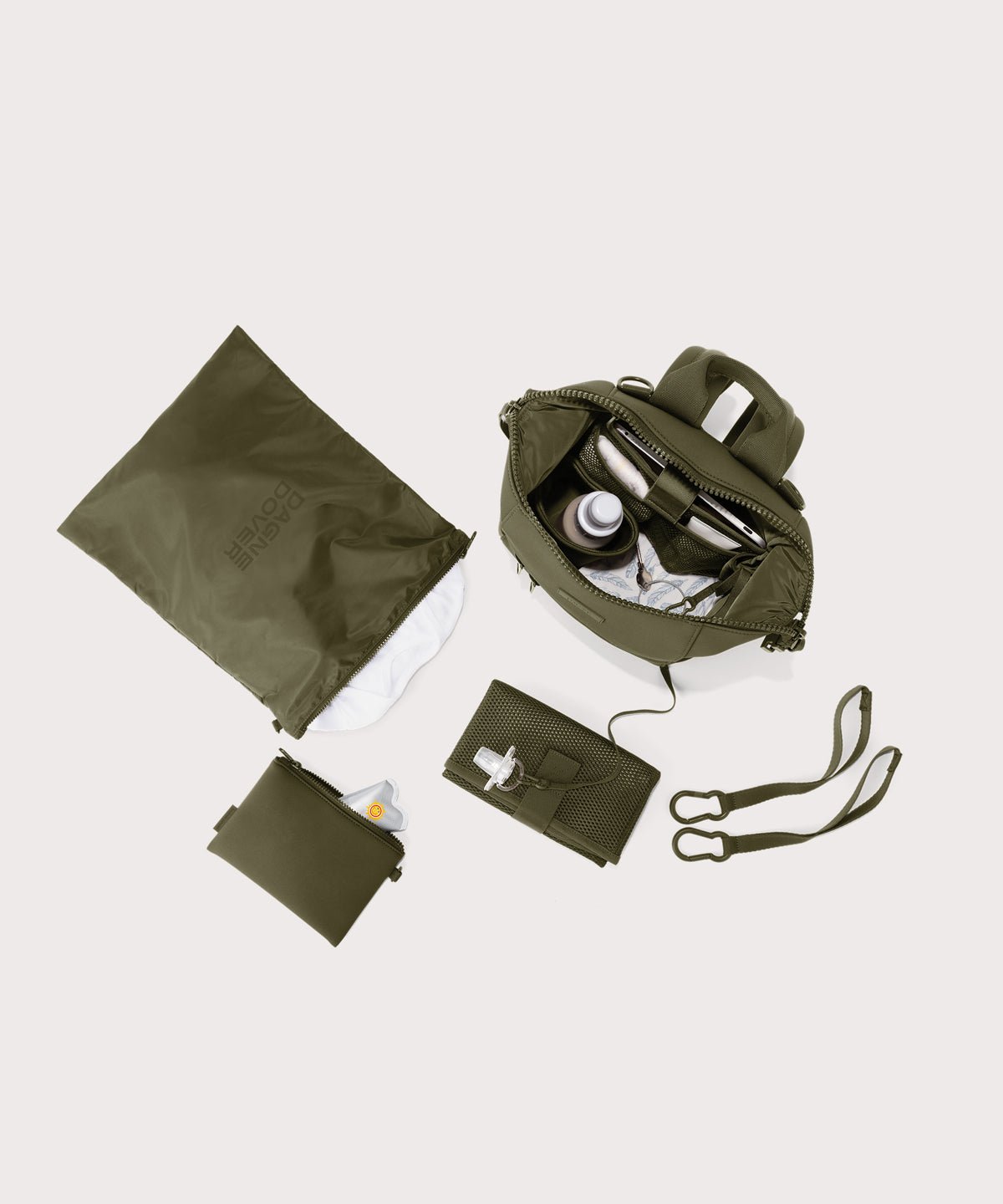 Dagne Dover small Indi Diaper Backpack in dark moss showing it's water resistant bag, interior pockets, and changing mat.