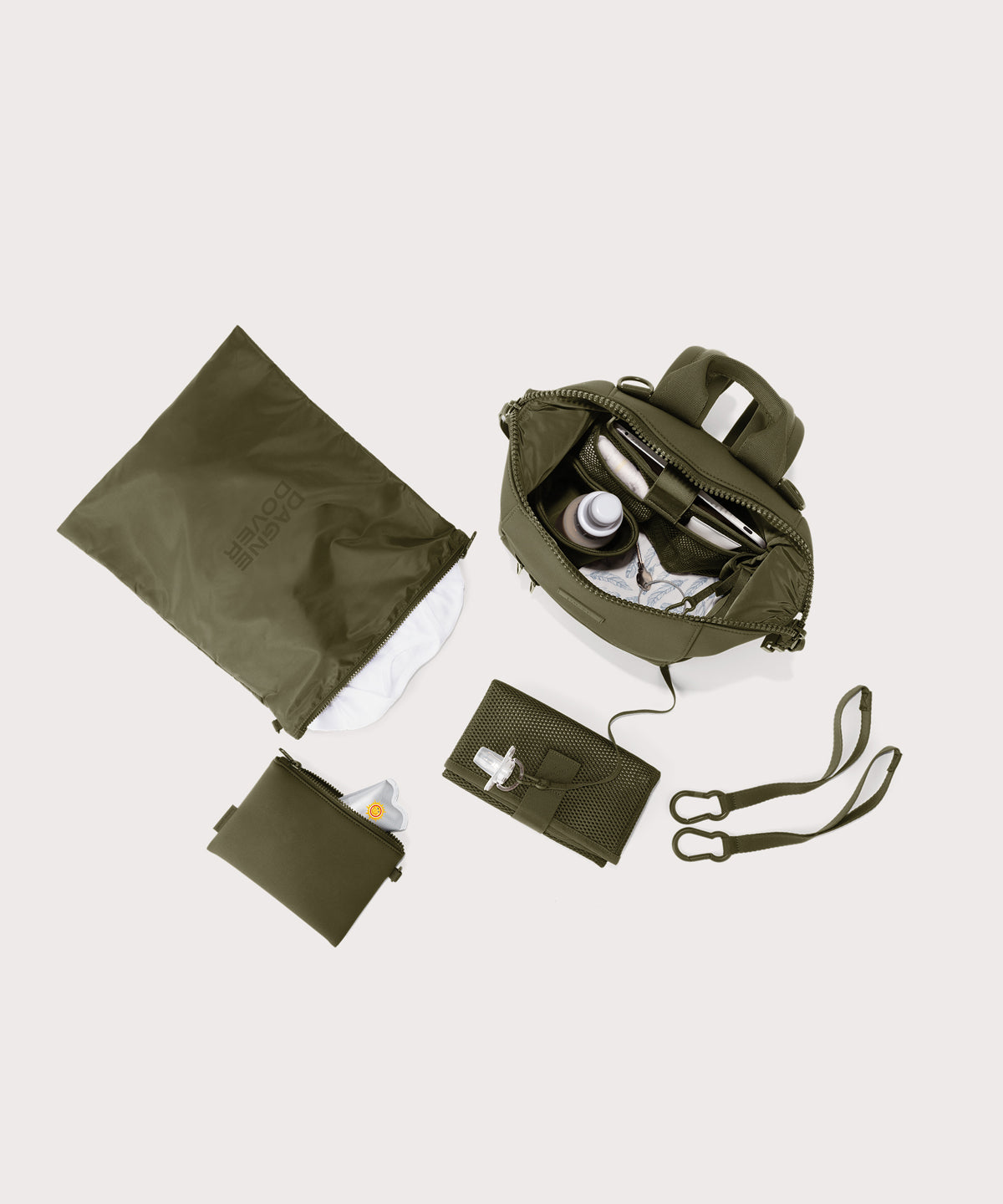 Dagne Dover small Indi Diaper Backpack in dark moss showing it's water resistant bag, interior pockets, and changing mat.