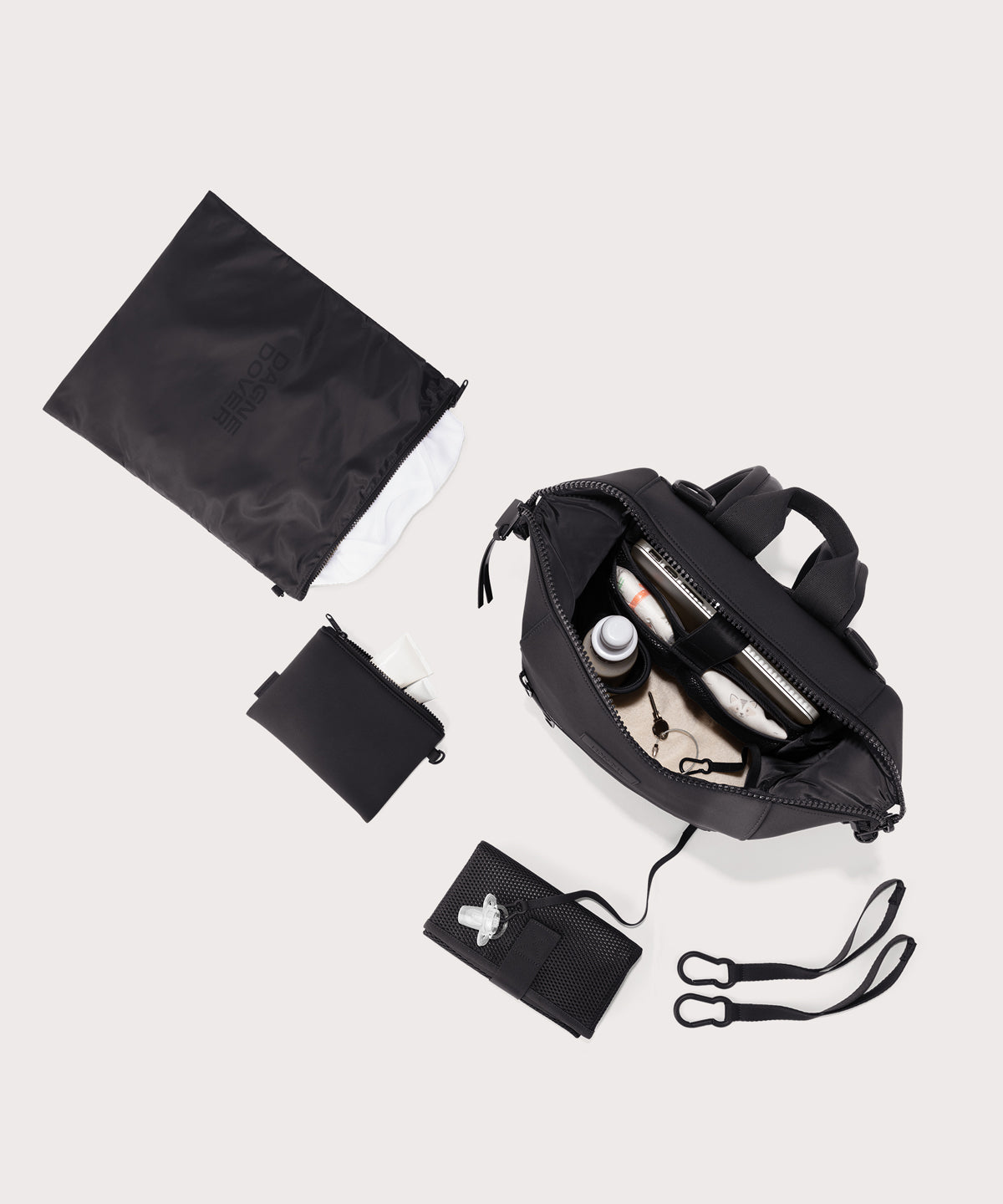 agne Dover medium Indi Diaper Backpack in black showing it's water resistant bag, interior pockets, and changing mat.