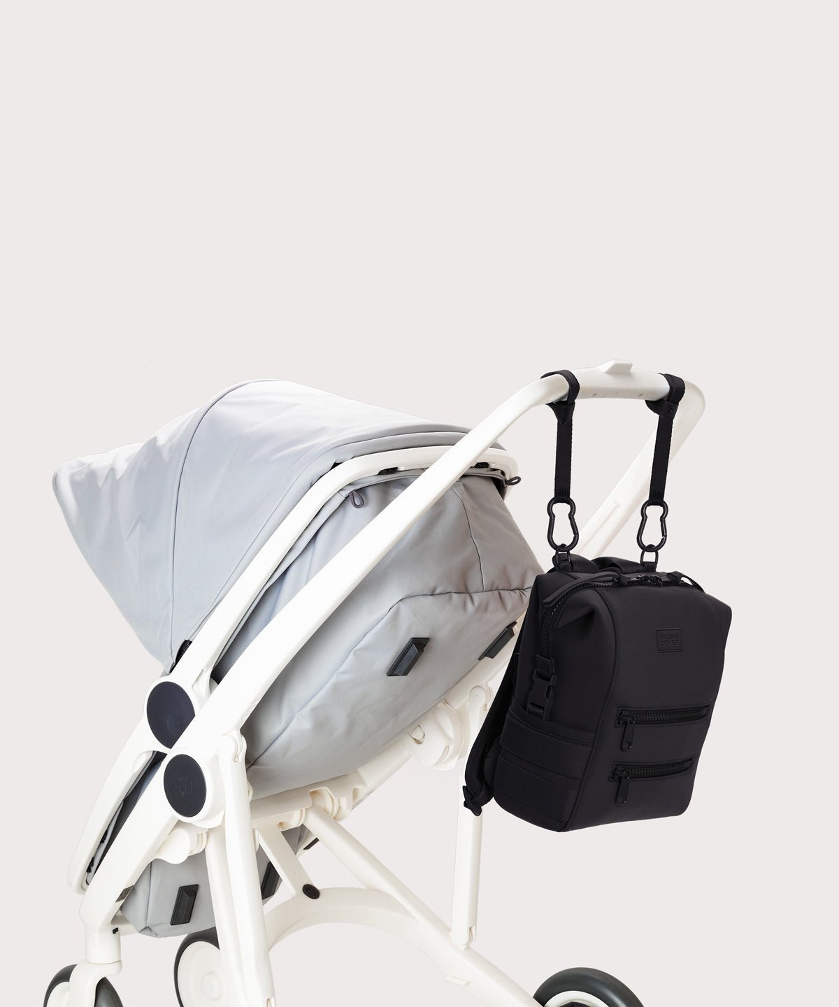 Dagne Dover small Indi Diaper Backpack in black attached to a stroller.
