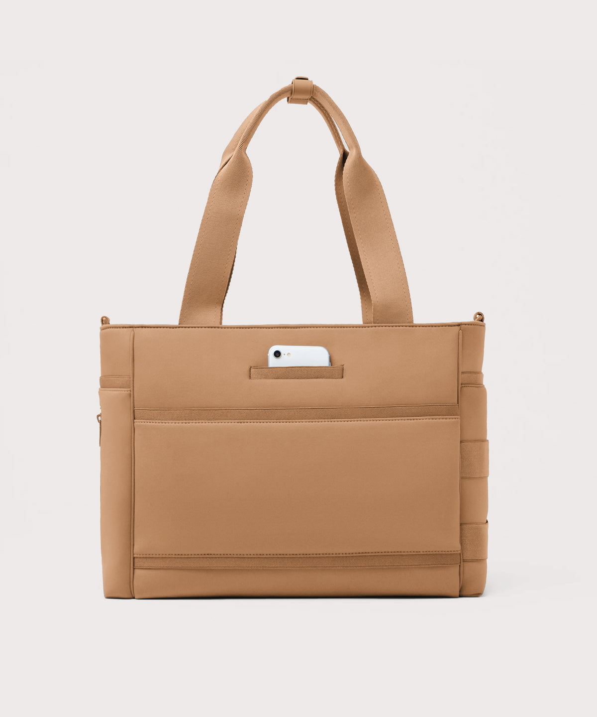 Dagne Dover large Wade Diaper Tote in camel brown seen from the back with a phone in the exterior phone pocket.
