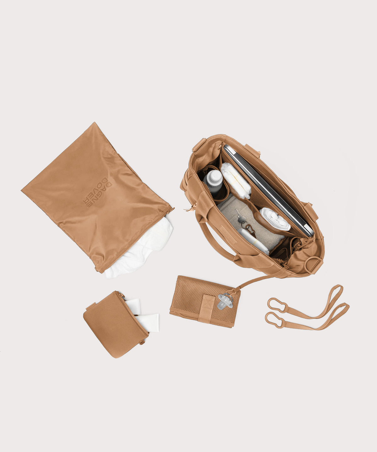 Dagne Dover large Wade Diaper Tote in camel brown seen from above, alongside the changing mat, neoprene pouch, and water resistant zipper bag.