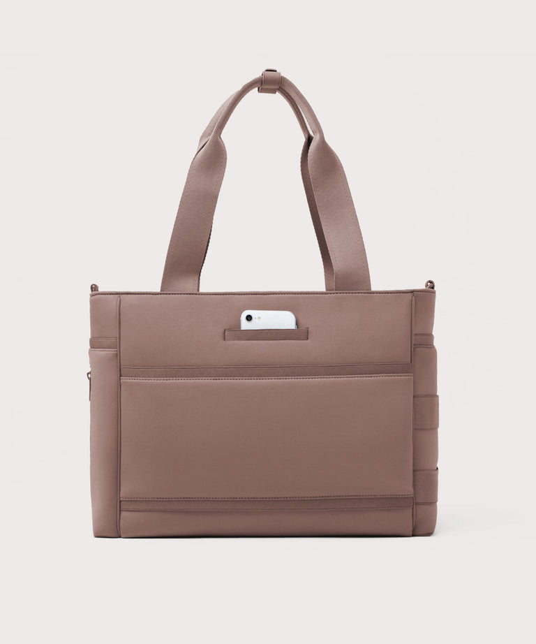 Dagne Dover large Wade Diaper Tote in pink seen from the back with a phone in the exterior phone pocket.
