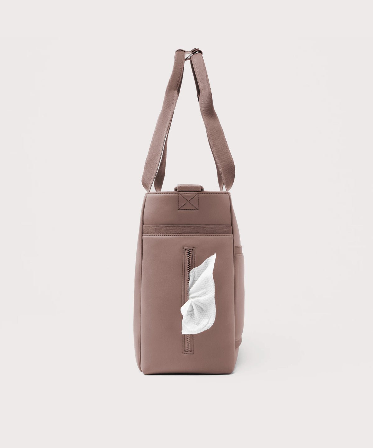 Dagne Dover large Wade Diaper Tote in pink seen from the side, with a wet wipe poking out of the slip pocket.
