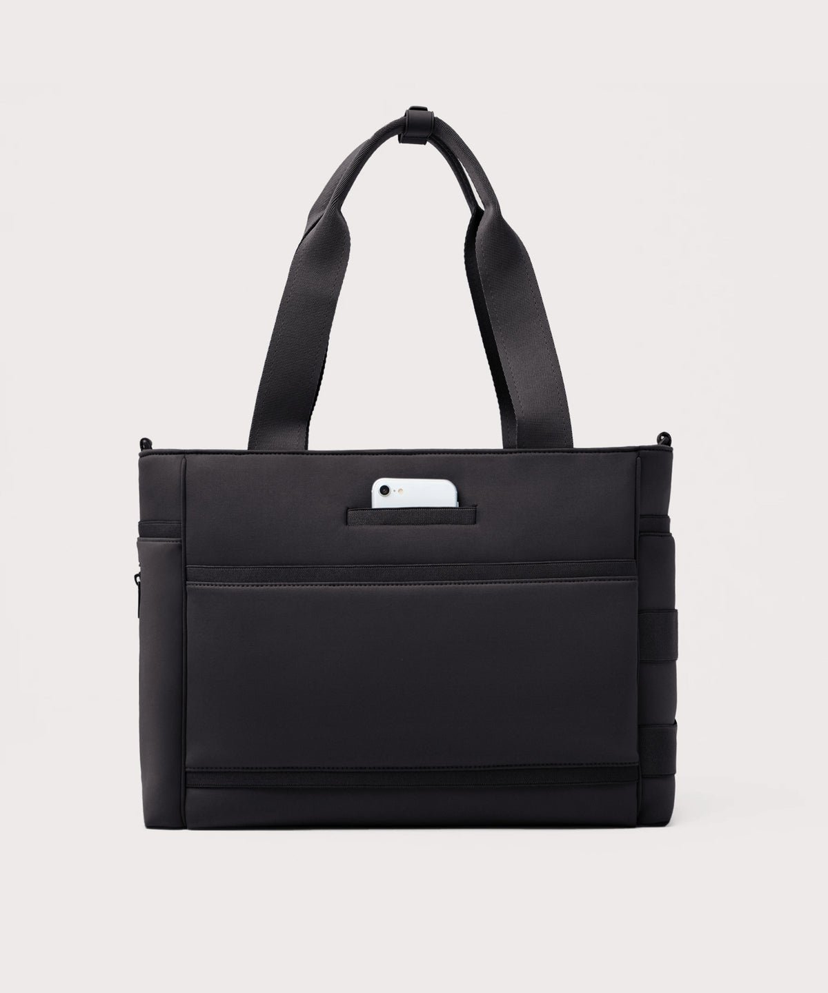 Dagne Dover large Wade Diaper Tote in black seen from the back with a phone in the exterior phone pocket.
