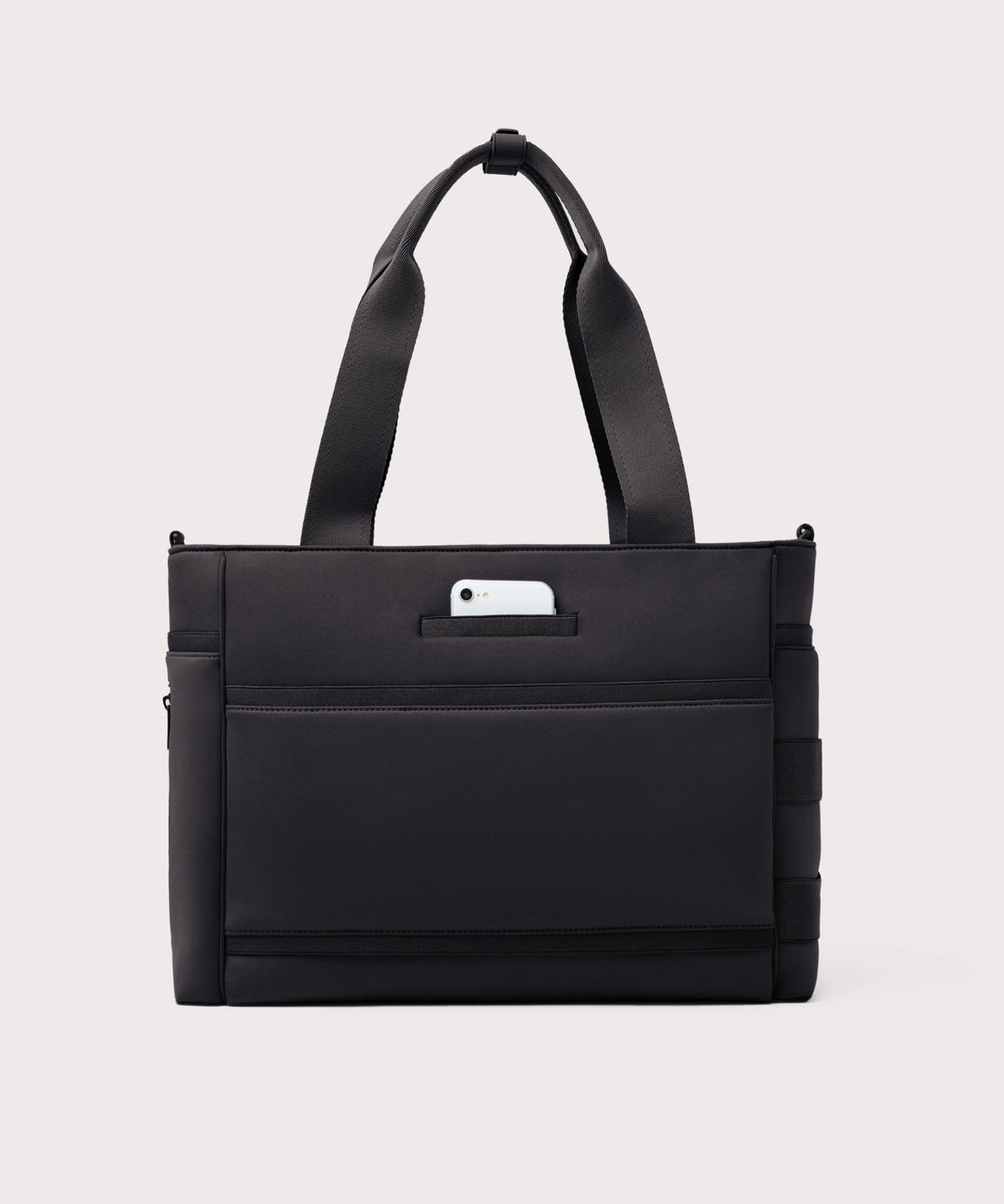Dagne Dover large Wade Diaper Tote in black seen from the back with a phone in the exterior phone pocket.
