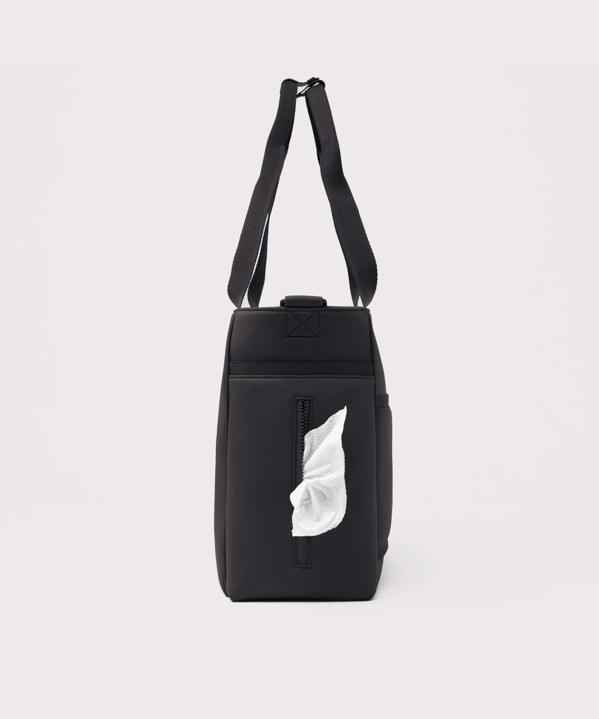Dagne Dover large Wade Diaper Tote in black seen from the side, with a wet wipe poking out of the slip pocket.
