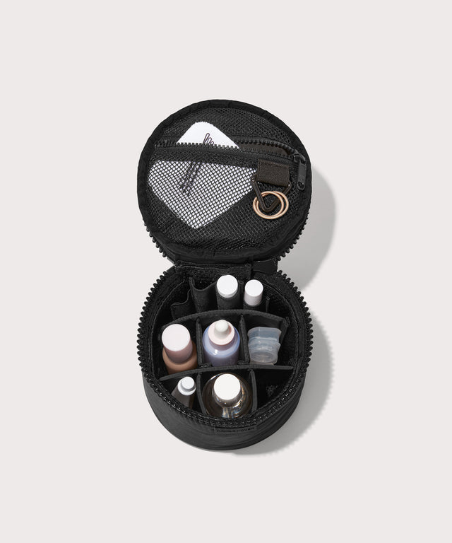 Dagne Dover small Mila Toiletry Pouch in black unzipped filled with toiletry products.
