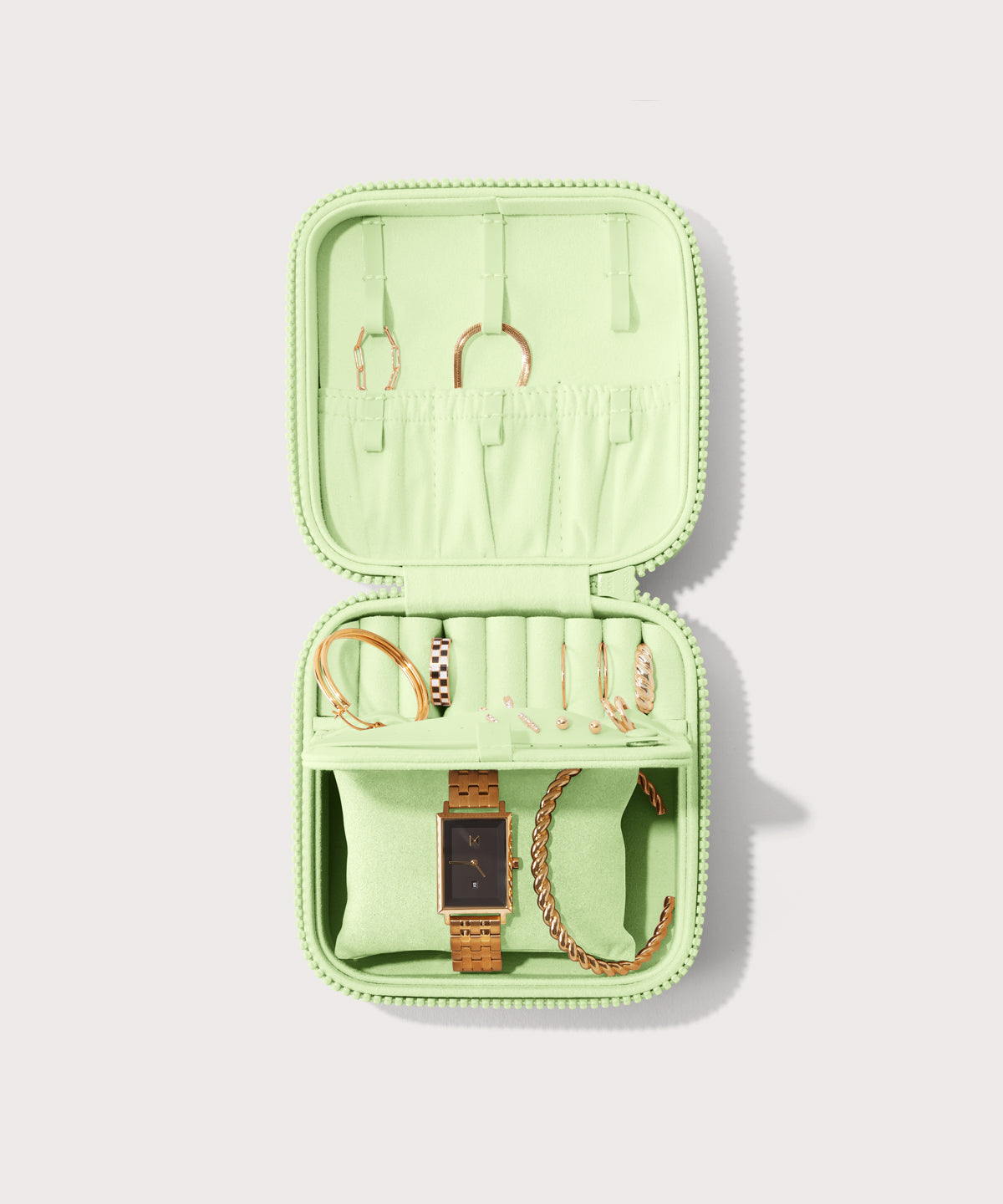 Dagne Dover Large Frankie Jewelry Case in matcha green, seen open from above with jewelry inside the interior compartment.