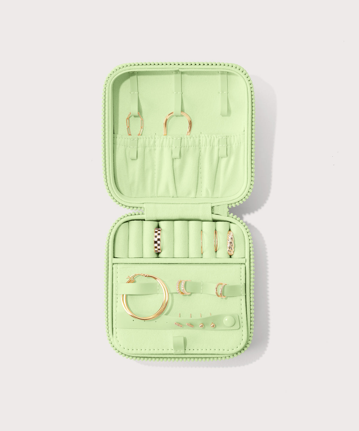 Dagne Dover Large Frankie Jewelry Case in matcha green, seen open from above with jewelry inside the interior compartment.