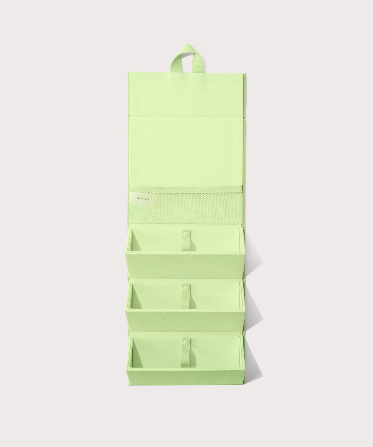 Dagne Dover Remi foldable glasses holder in matcha green hung up.
