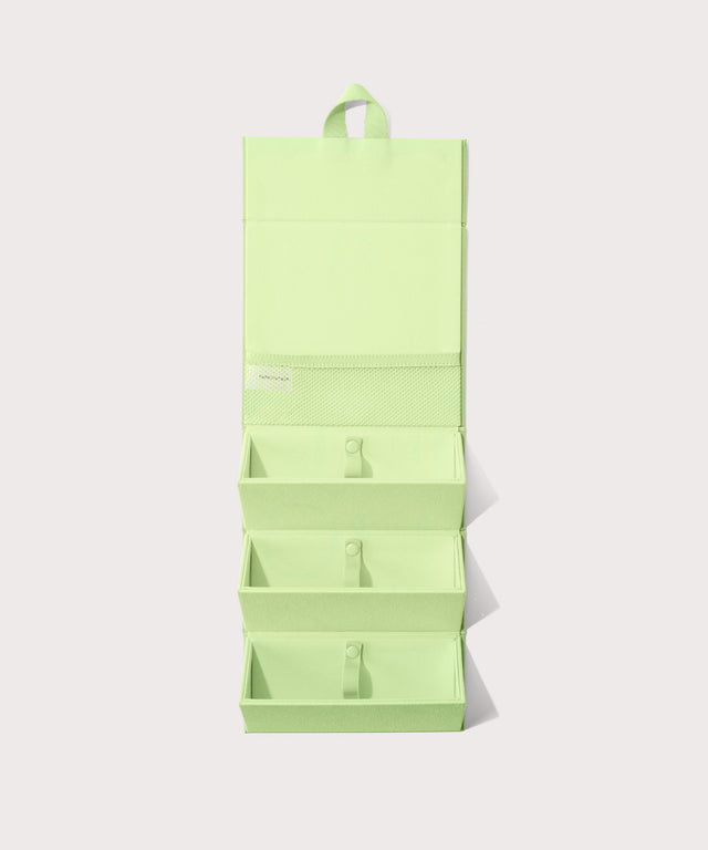 Dagne Dover Remi foldable glasses holder in matcha green hung up.

