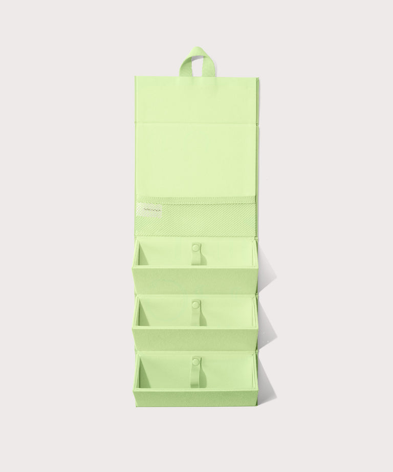 Dagne Dover Remi foldable glasses holder in matcha green hung up.
