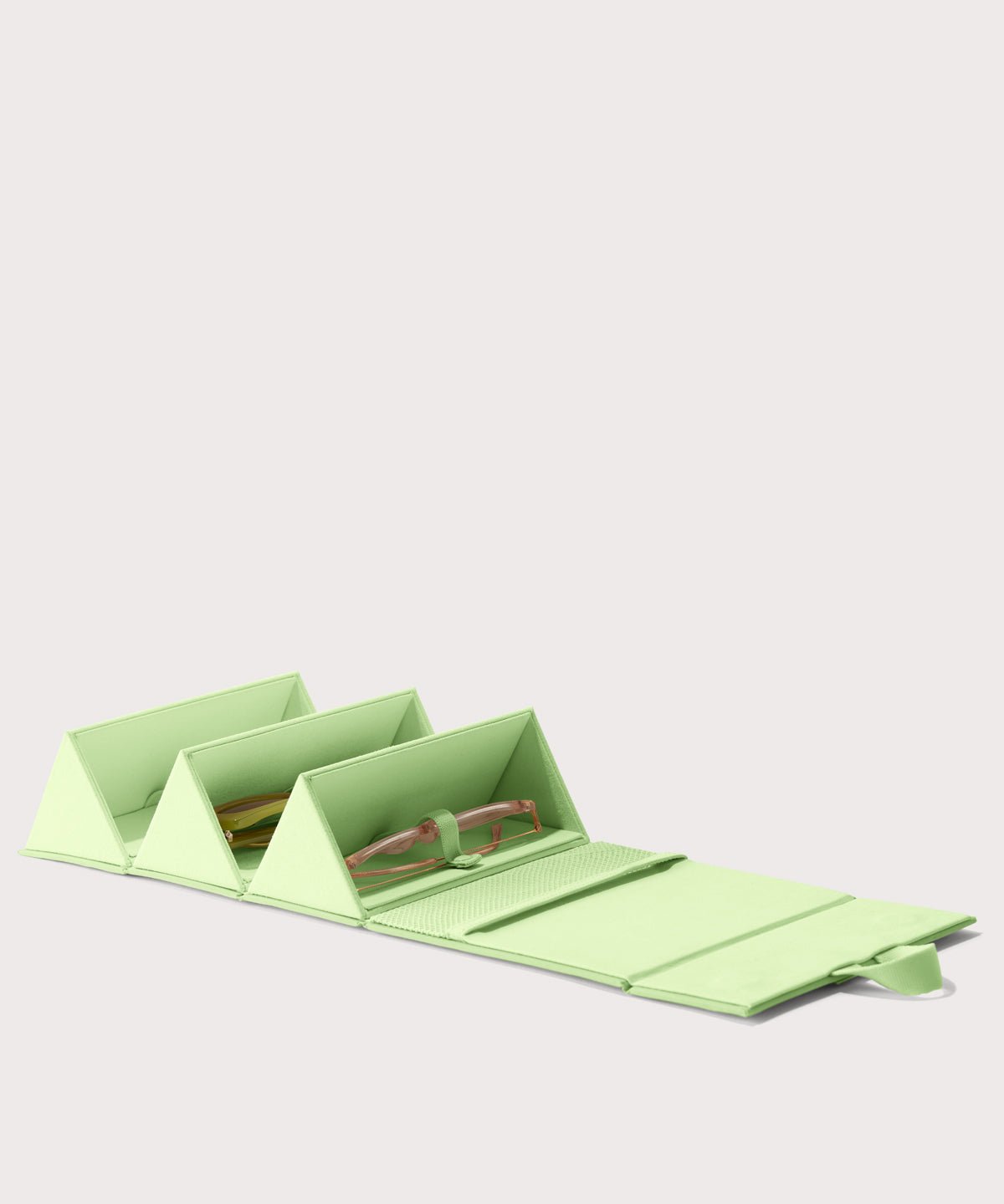 Dagne Dover Remi foldable glasses holder in matcha green hung up.
