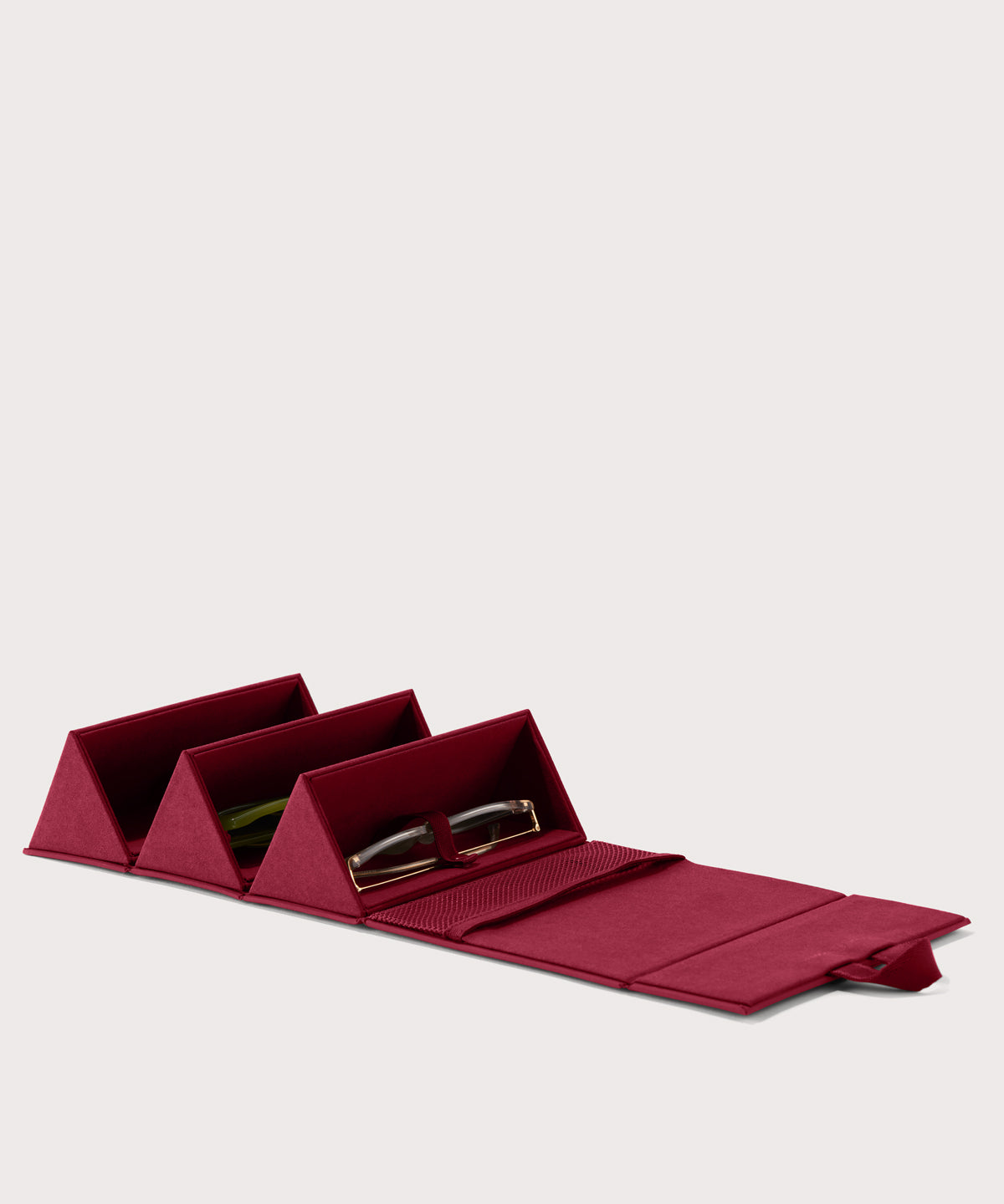 Dagne Dover Remi foldable glasses holder in spice red, unfolded and containing sunglasses.
