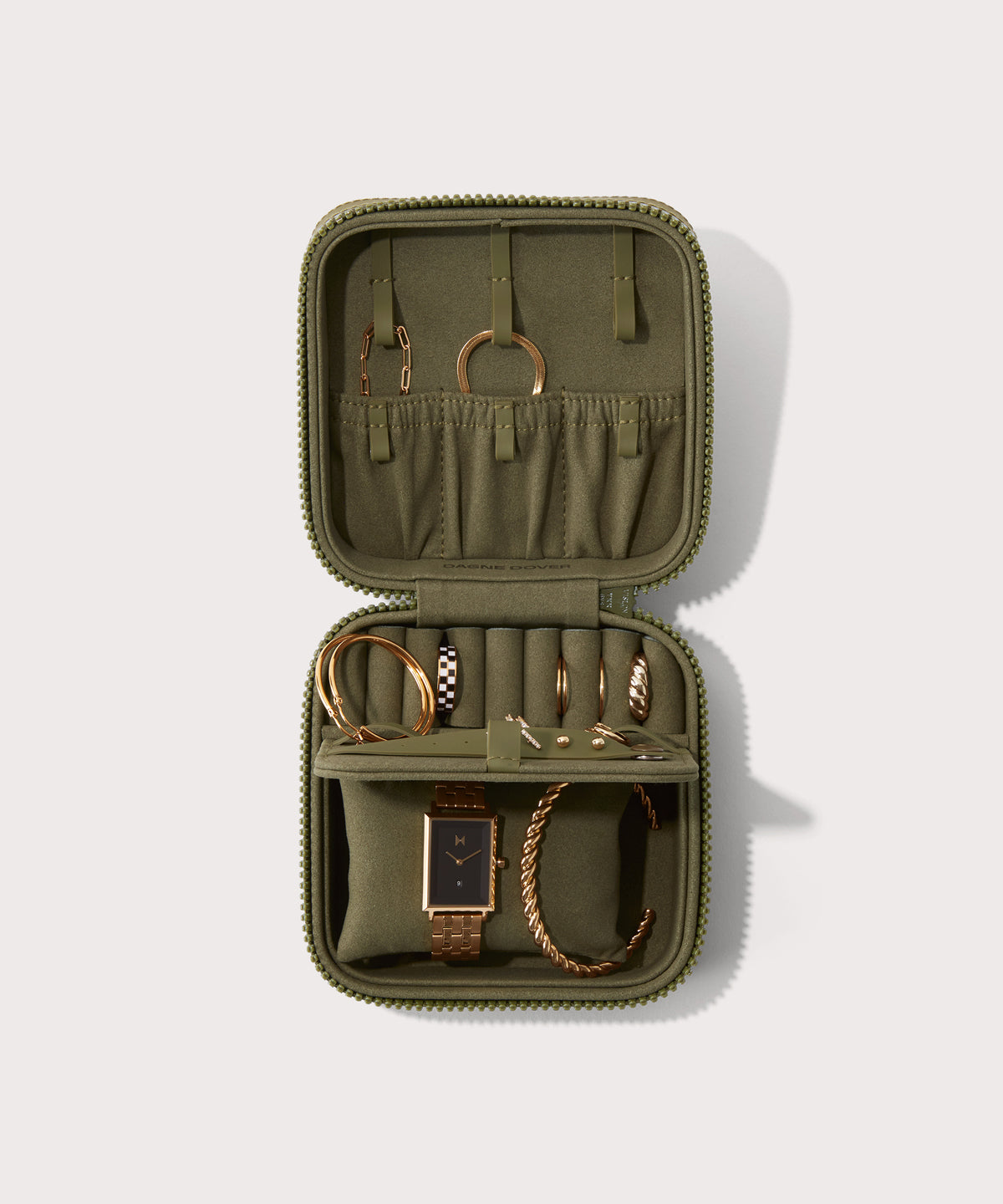 Dagne Dover Large Frankie Jewelry Case in dark green, seen open from above with jewelry inside the interior compartment.