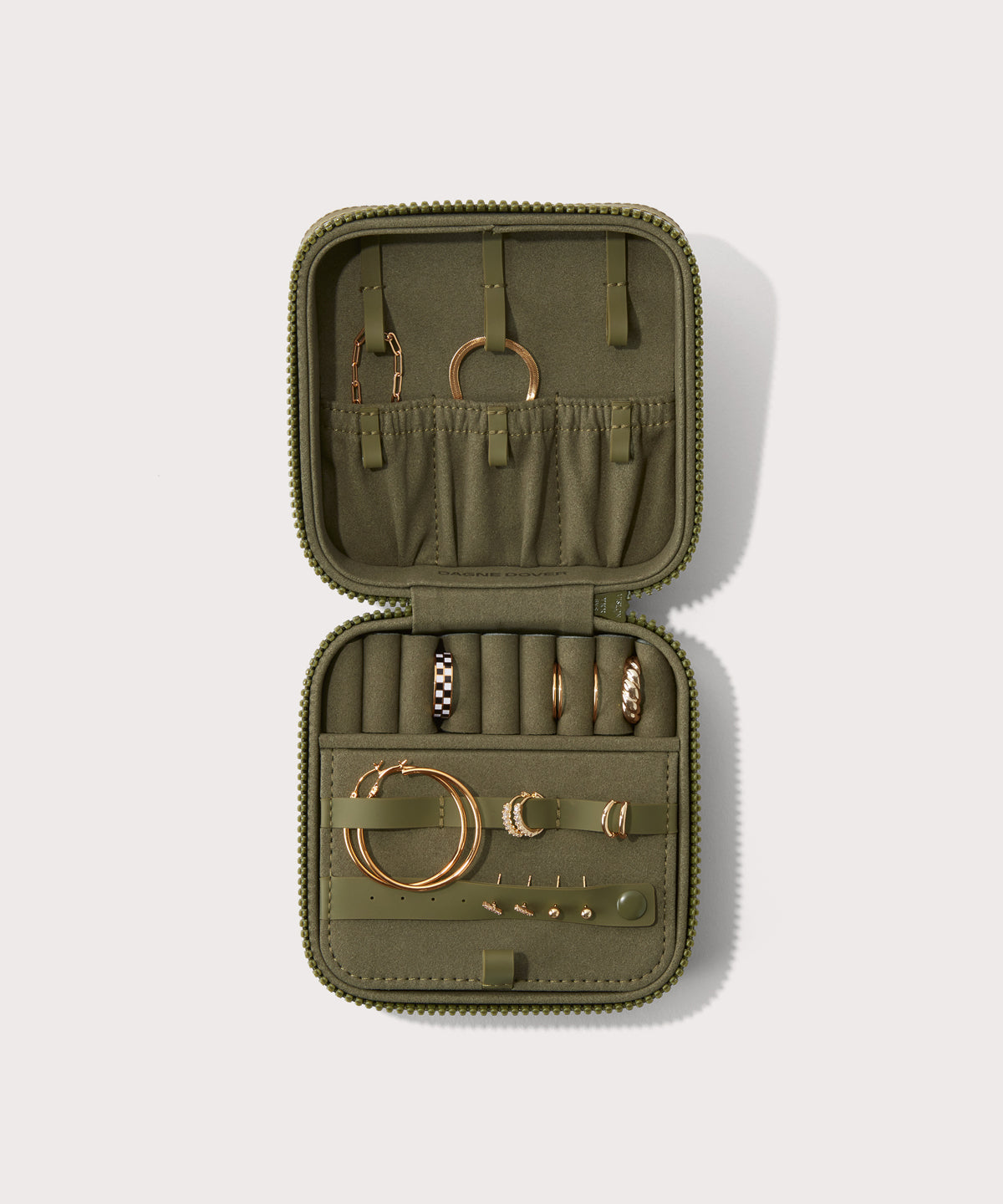 Dagne Dover Large Frankie Jewelry Case in dark green, seen open from above with jewelry inside the interior compartment.