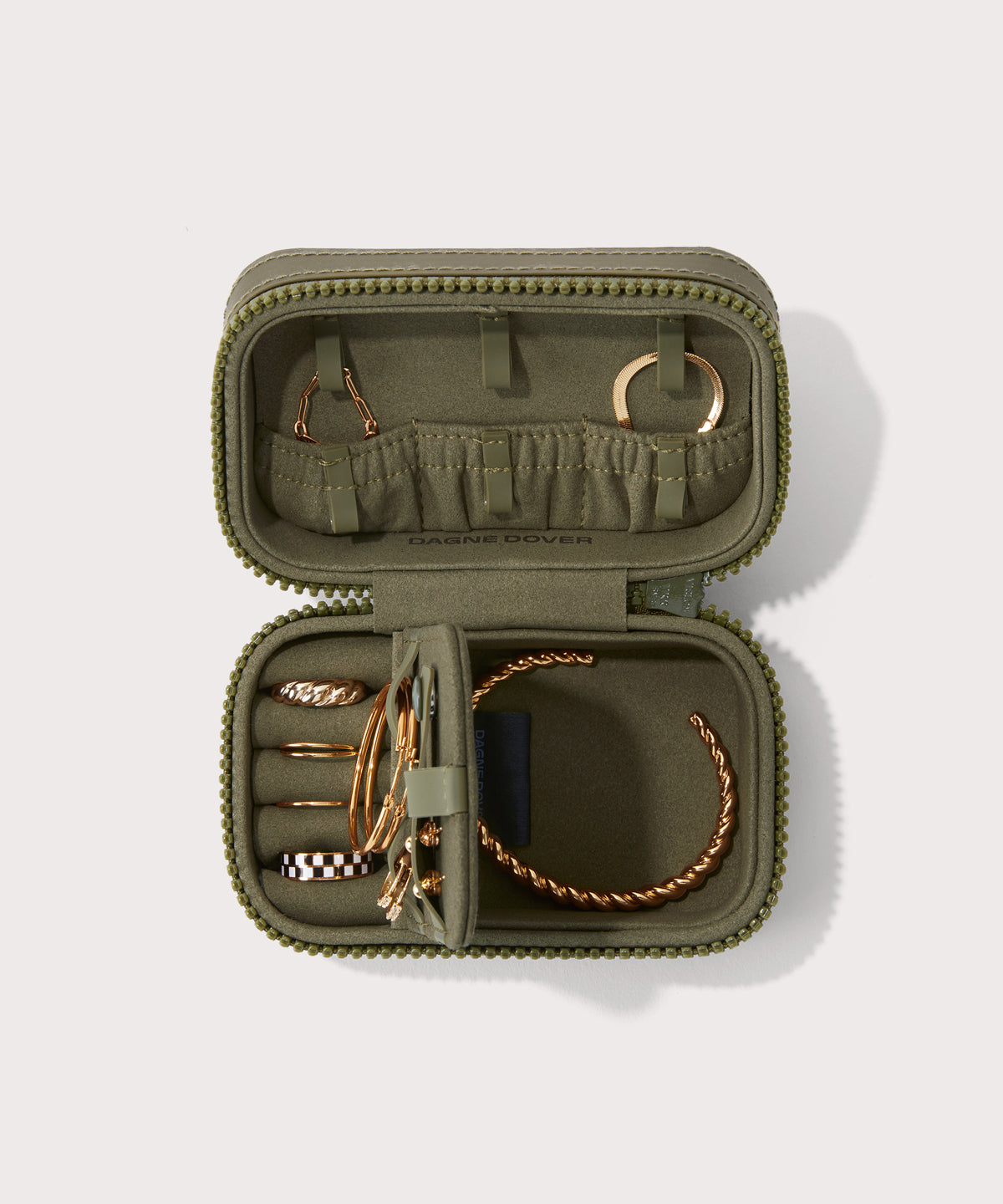 Dagne Dover small Frankie Jewelry Case in dark green, seen open from above with jewelry inside the interior compartment.
