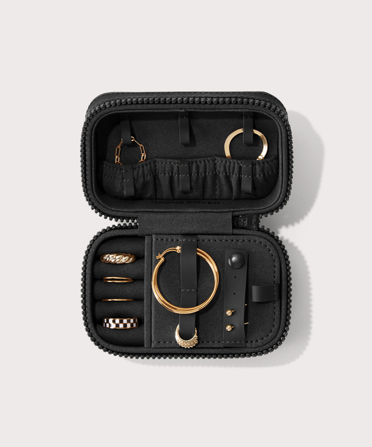 Dagne Dover small Frankie Jewelry Case in black, seen open from above with jewelry inside the interior compartment.